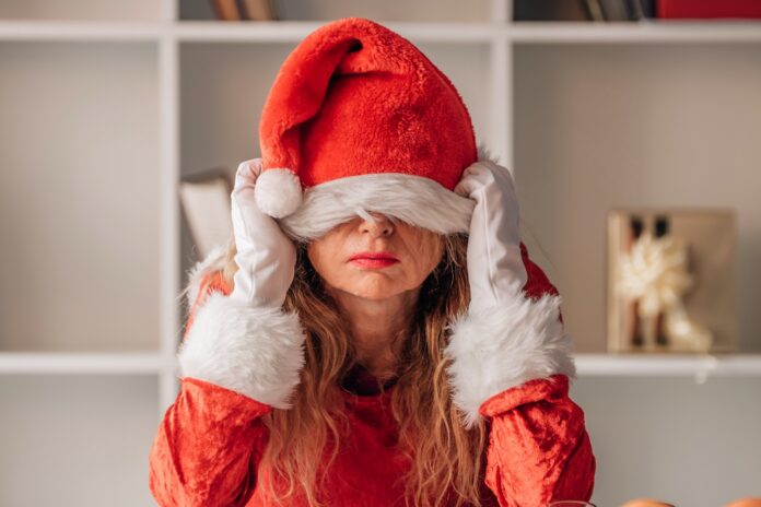 Frau mit Weihnachtsmütze über den augen